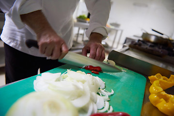 Image showing chef in hotel kitchen  slice  vegetables with knife