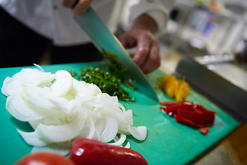 Image showing chef in hotel kitchen  slice  vegetables with knife