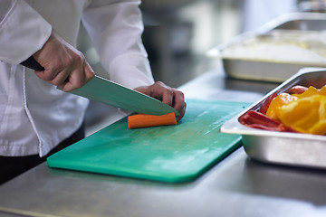 Image showing chef in hotel kitchen  slice  vegetables with knife