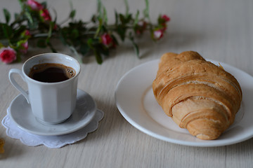 Image showing cup of strong coffee and a croixant 