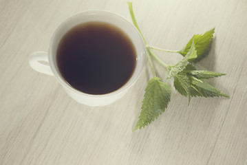 Image showing cup of nettle tea with fresh nettle