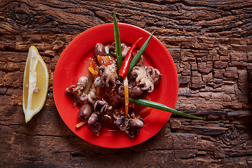 Image showing Baby octopuses in red dish