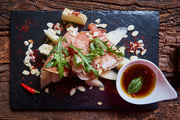 Image showing salad of fresh melon with thin slices prosciutto