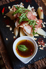 Image showing salad of fresh melon with thin slices prosciutto