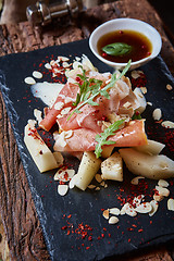 Image showing salad of fresh melon with thin slices prosciutto