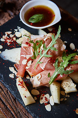 Image showing salad of fresh melon with thin slices prosciutto