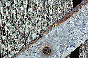 Image showing Closeup head of big metal screw on wooden plate