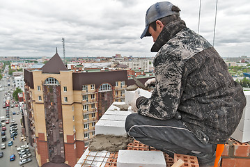 Image showing Bricklayer on construction over street traffic