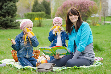 Image showing Two girls eating a banana on a picnic