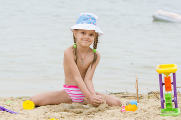 Image showing Five-year girl on a river in the sand beach Flashes