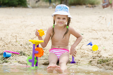 Image showing Five-year girl playing on the river sand