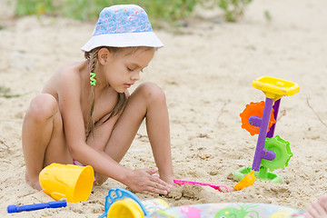 Image showing Five-year girl on the river playing in the sand