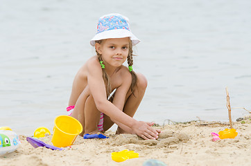 Image showing Five-year girl on the beach playing in the sand