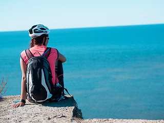 Image showing Woman sitting om rock over sea landscape