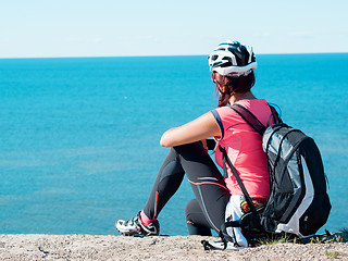 Image showing Woman sitting om rock over sea landscape