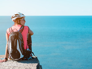 Image showing Woman sitting om rock over sea landscape