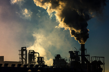 Image showing Smoking chimney  at sunset 