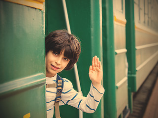 Image showing boy waves his hand from railcar