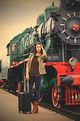 Image showing woman traveler with luggage near retro puffer