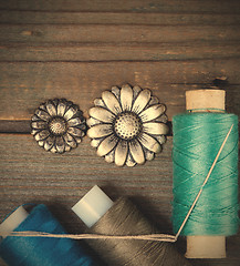 Image showing two vintage buttons flowers and spools with threads