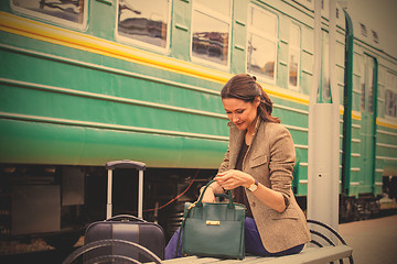 Image showing beautiful woman rummages in a bag