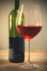 Image showing red wine in goblet and green bottle