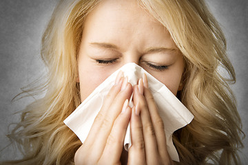 Image showing Ill woman with tissue is sneezing