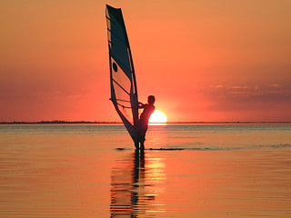 Image showing Silhouette of a windsurfer on waves of a gulf on a sunset 4