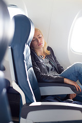 Image showing Lady traveling napping on a plain.