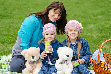 Image showing Mum embraces daughters on a picnic