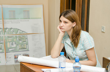 Image showing Sad student sitting at desk with drawings