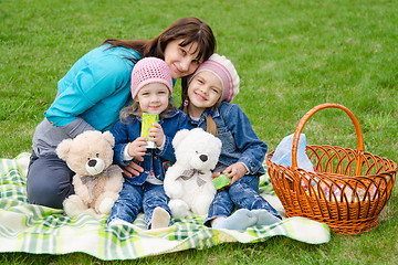 Image showing Mum embraces daughters on a picnic