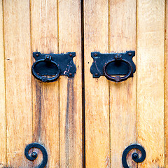 Image showing handle in london antique brown door  rusty  brass nail and light