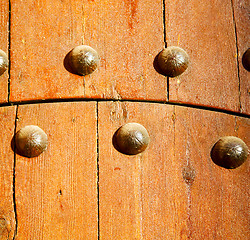 Image showing metal nail dirty stripped paint in the brown   red wood door and