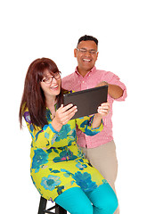 Image showing A middle age couple having fun with the tablet.