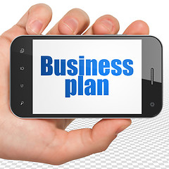 Image showing Finance concept: Business Plan on Hand Holding Smartphone display