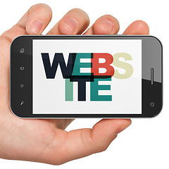 Image showing Web development concept: Hand Holding Smartphone with Website on display
