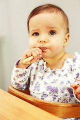 Image showing Small cute baby eating