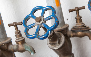 Image showing Old pipelines with blue valve