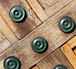 Image showing in london antique brown door  rusty  brass nail and light