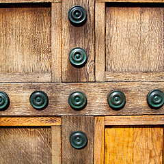 Image showing in london antique brown door  rusty  brass nail and light