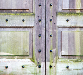 Image showing in london antique brown door  rusty  brass nail and light