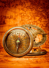 Image showing Vintage compass lies on an ancient world map.