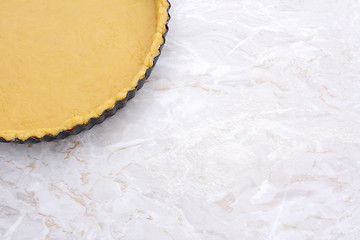 Image showing Baking tin lined with pastry on worktop