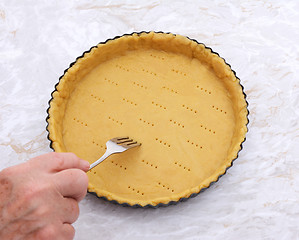 Image showing Woman finishes pricking holes in a pastry pie crust