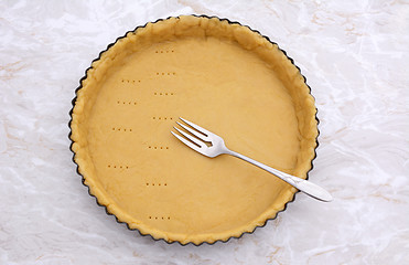 Image showing Pricking shortcrust pastry case with a metal fork