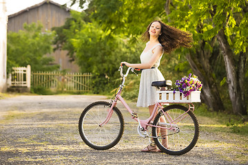 Image showing Happy girl with her bicycle