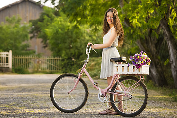 Image showing Happy girl with her bicycle