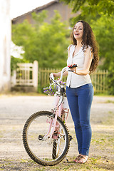 Image showing Girl with her bicycle