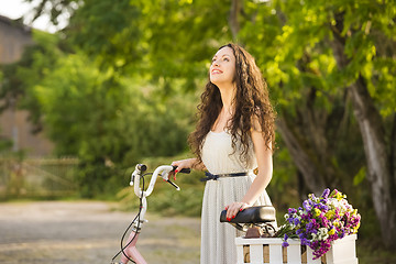 Image showing Happy girl with her bicycle